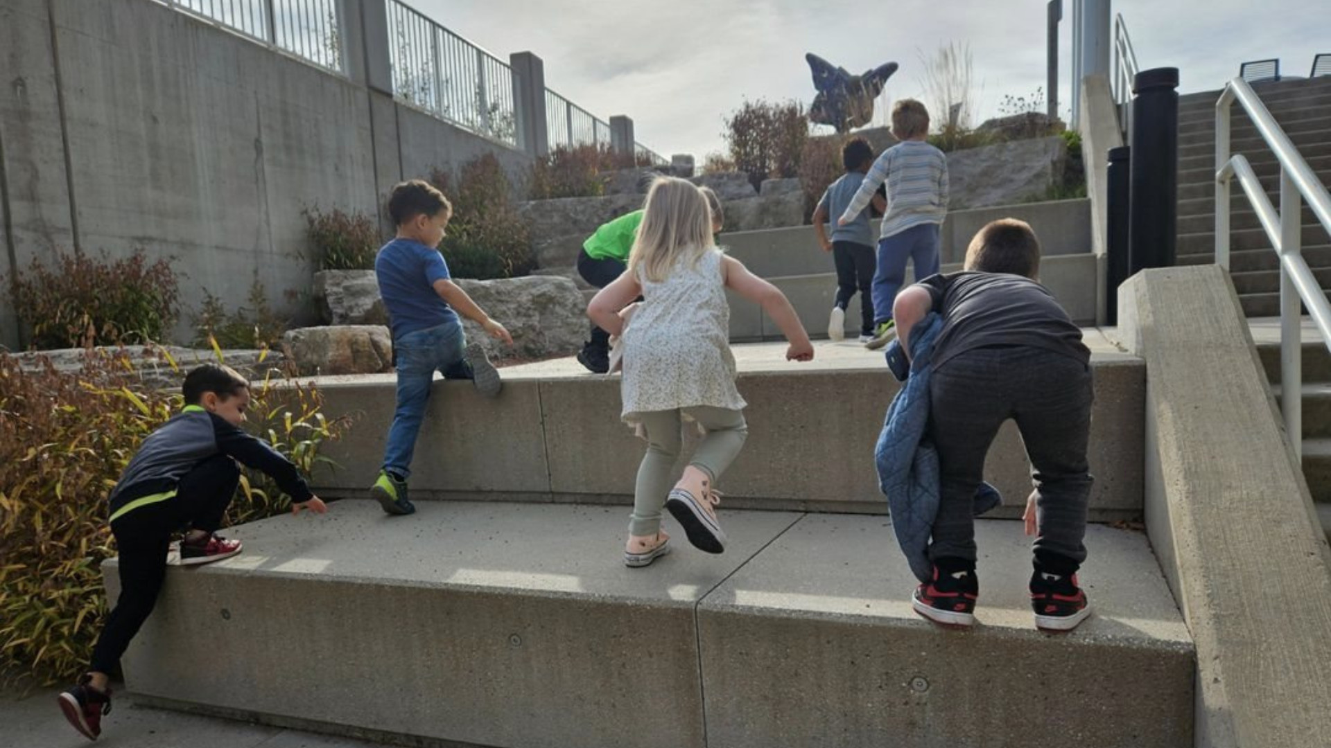 Children, facing away from the camera, climbing the stairs at the St. Charles' Public Library.