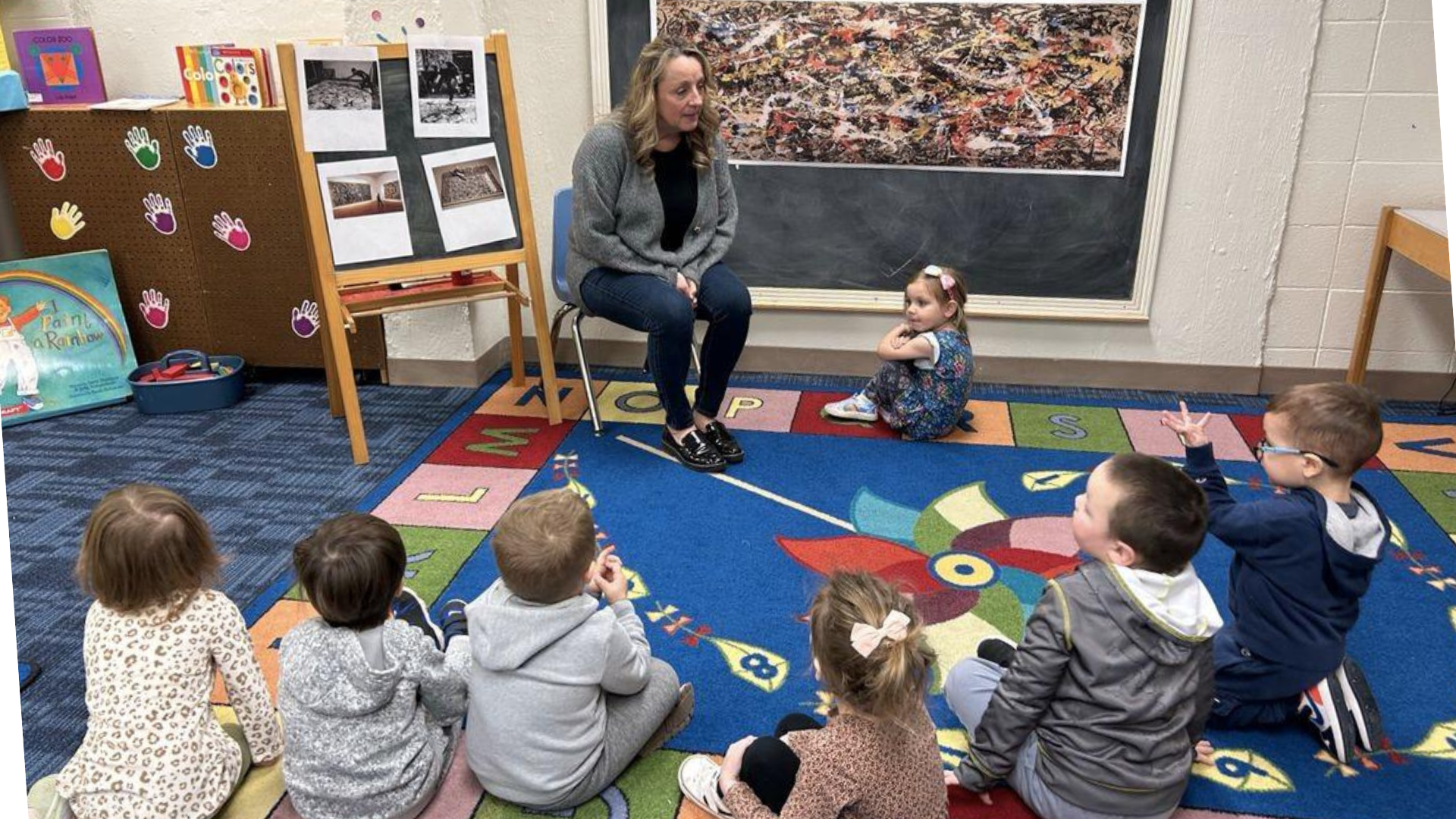 Children, facing away from the camera, learning about Jackson Pollock in the Wonder-Lab.